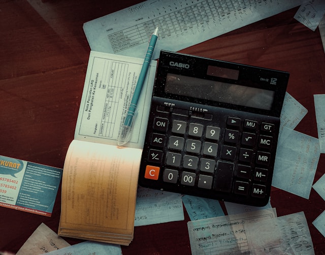 A person looking calmly at a laptop and organized papers on a table: "A calm, organized setup for conducting a personal money audit."